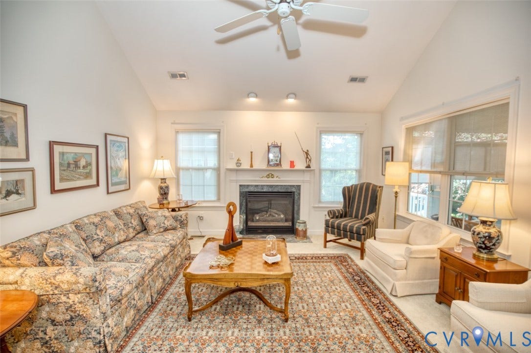 6311 Chiswick Park, Williamsburg, VA 23188 Bright, light-filled living room featuring vaulted ceilings with ceiling fan, gas fireplace with surround, recessed lighting, and French doors with transom windows opening to natural light