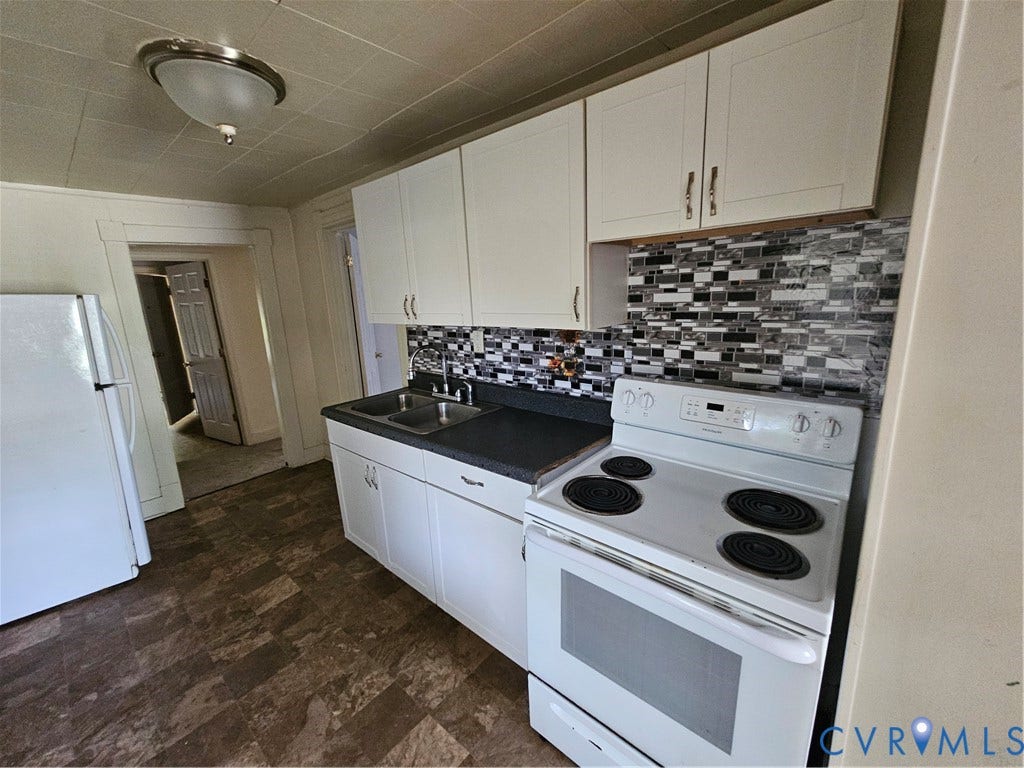 1601 Byron Street, Henrico, VA 23222 Galley kitchen featuring white cabinetry with ample storage, black laminate countertops, a geometric tile backsplash, and white electric range with coil burners