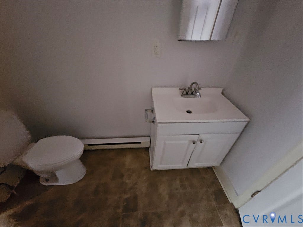 1601 Byron Street, Henrico, VA 23222 Functional half bathroom featuring a white ceramic pedestal sink with chrome faucet, a standard toilet, wood-finish flooring, and recessed ceiling lighting