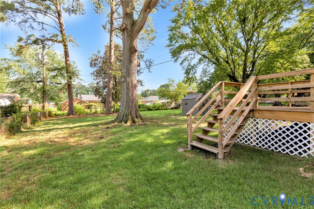 2807 Rothland Drive, Henrico, VA 23294 Expansive backyard featuring a wood deck with stairs, a storage shed, and mature trees