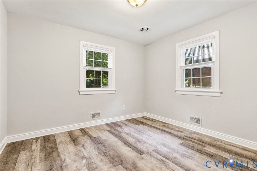 2807 Rothland Drive, Henrico, VA 23294 Light-toned walls, wood-finish flooring, two windows with white trim, and a ceiling-mounted light fixture