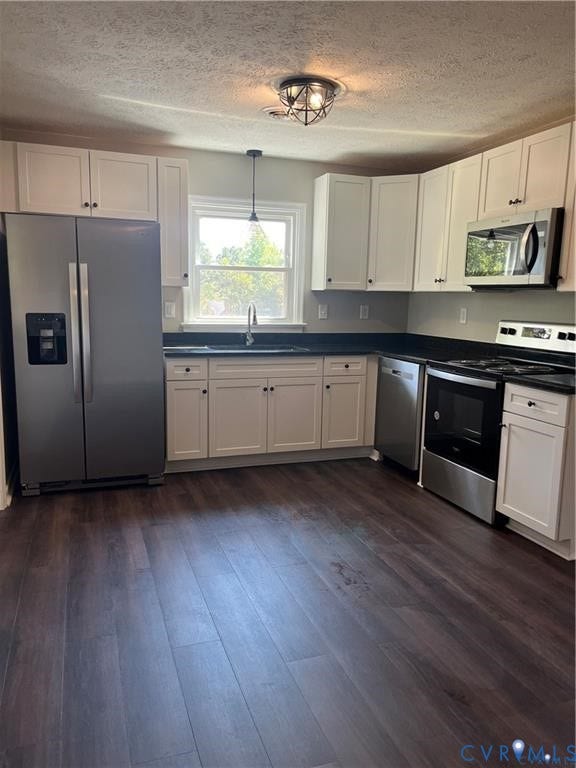 7032 Claybird Lane, Mechanicsville, VA 23111 Kitchen featuring wood-finish flooring, white cabinetry, dark countertops, and stainless steel appliances