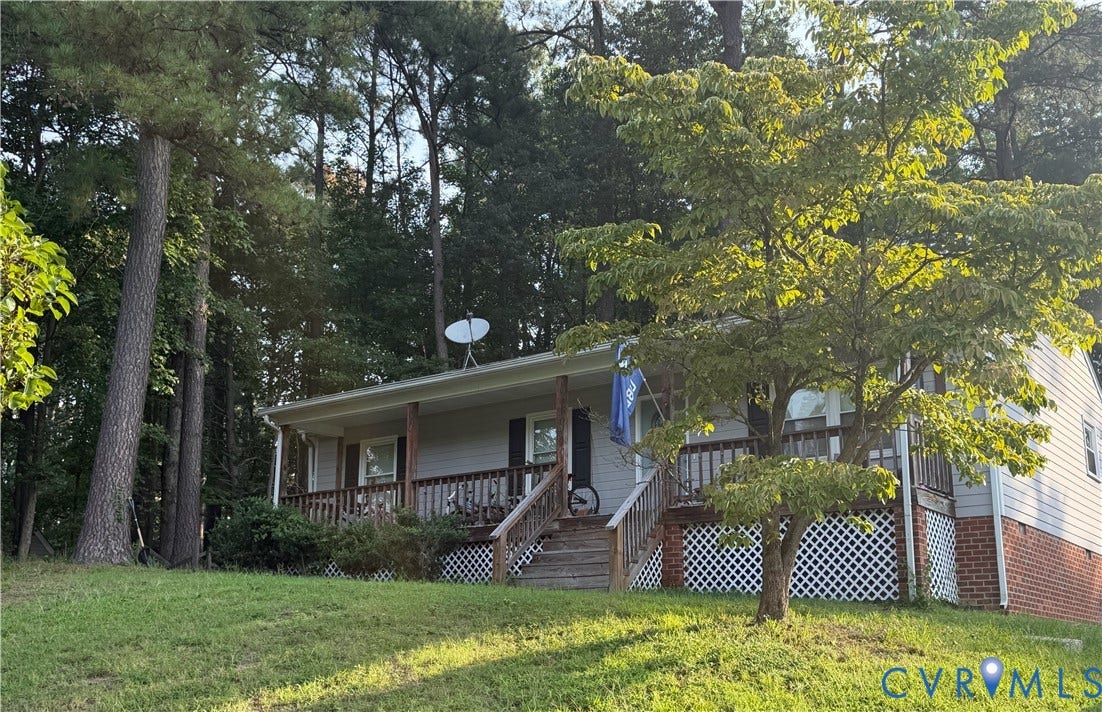 7032 Claybird Lane, Mechanicsville, VA 23111 Front exterior featuring a covered porch, wood railing, and brick foundation