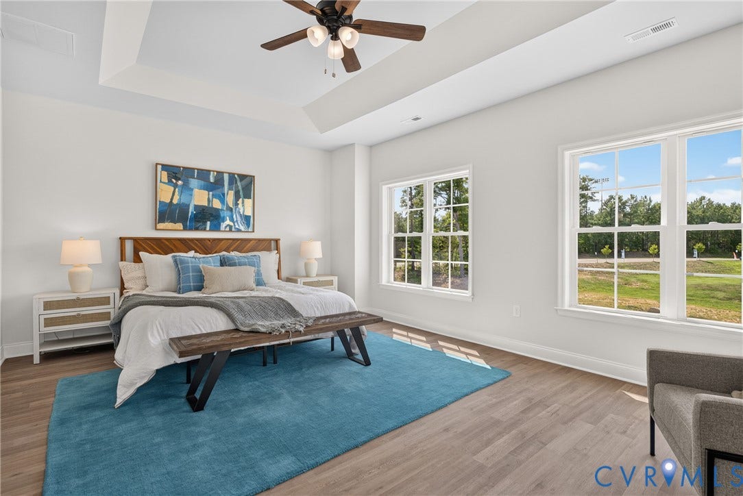 6537 Hardee Haven Place, Midlothian, VA 23112 Tray ceiling with integrated lighting, wood-finish flooring, ceiling fan with light fixture, and multiple windows providing natural light