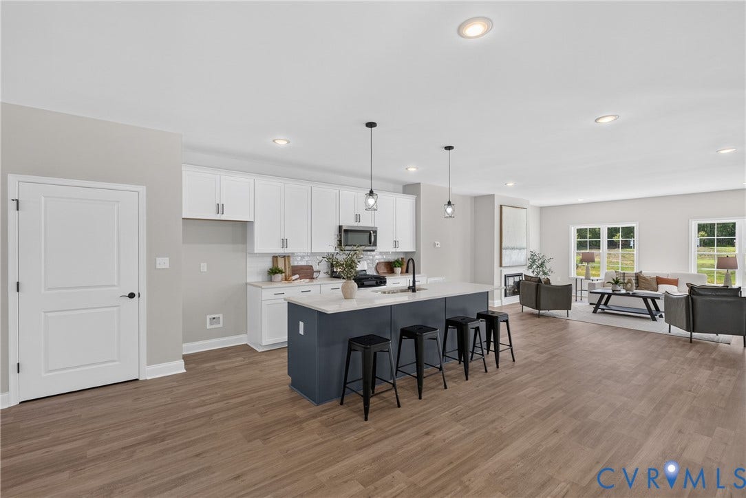 6537 Hardee Haven Place, Midlothian, VA 23112 Kitchen featuring white cabinetry, a dark-toned island with seating, a white backsplash, and wood-finish flooring