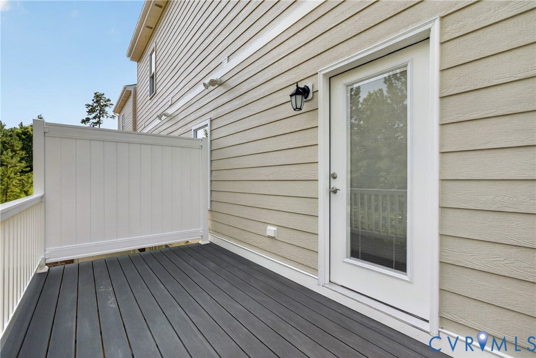 6537 Hardee Haven Place, Midlothian, VA 23112 Exterior deck featuring composite decking, white vinyl railing, and a full-light door with a matte black lantern-style sconce