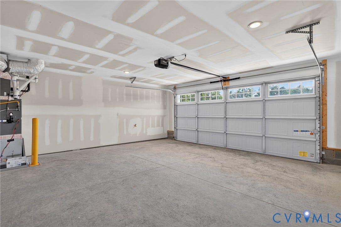 6537 Hardee Haven Place, Midlothian, VA 23112 Spacious garage with a concrete floor, equipped with a paneled garage door featuring transom windows and an automatic opener