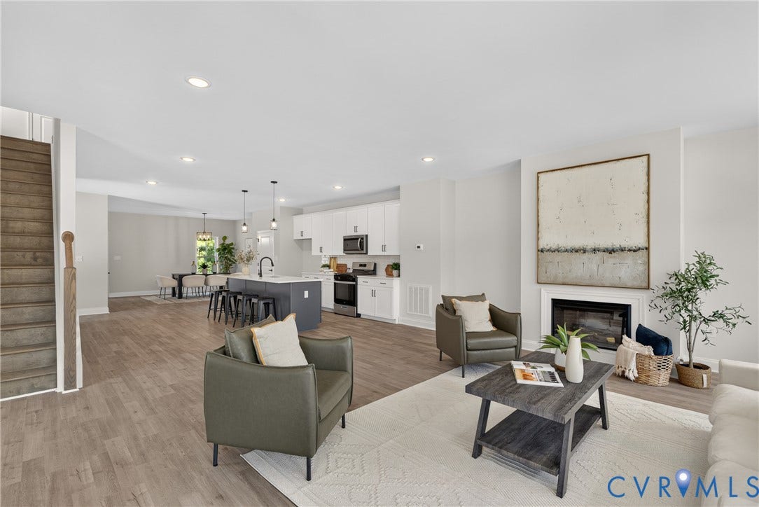 6537 Hardee Haven Place, Midlothian, VA 23112 Spacious open-concept living area featuring wood-finish flooring, a contemporary fireplace, recessed lighting, and a kitchen island with pendant lighting