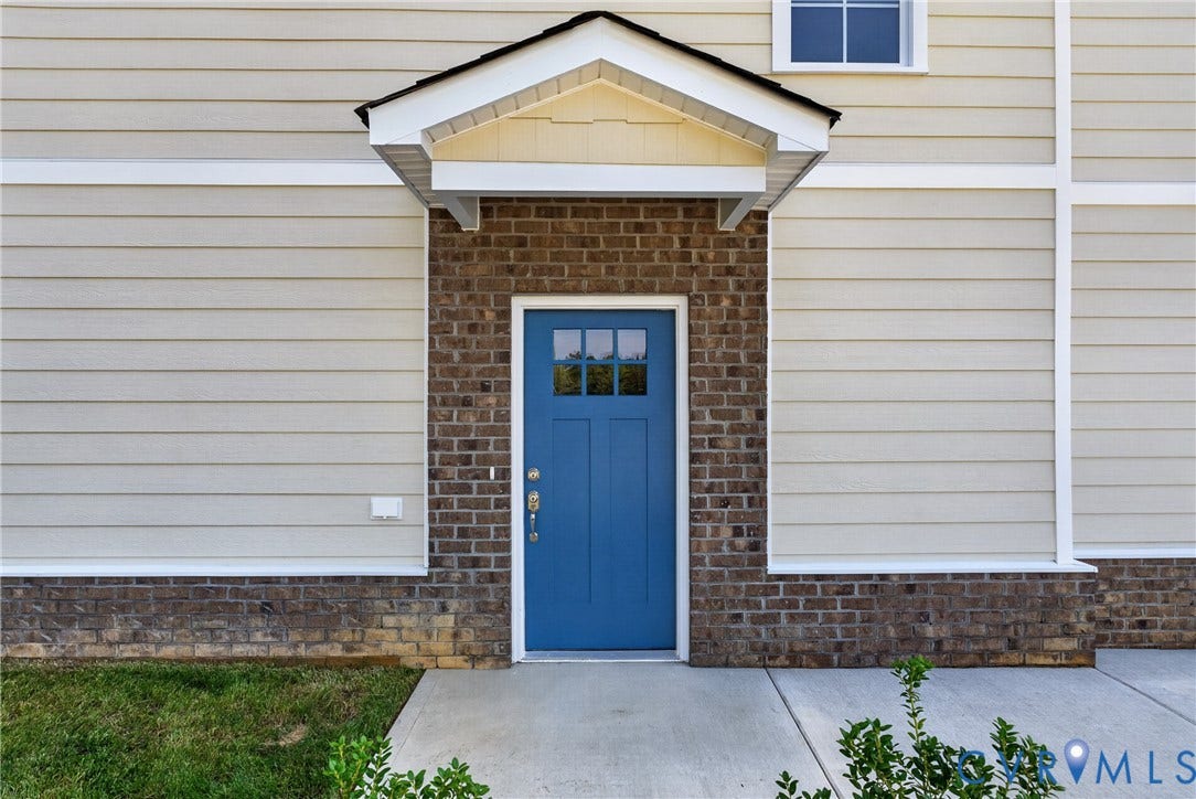 6537 Hardee Haven Place, Midlothian, VA 23112 Entryway featuring a bright blue door with window panes, brick facade, and a covered porch overhang