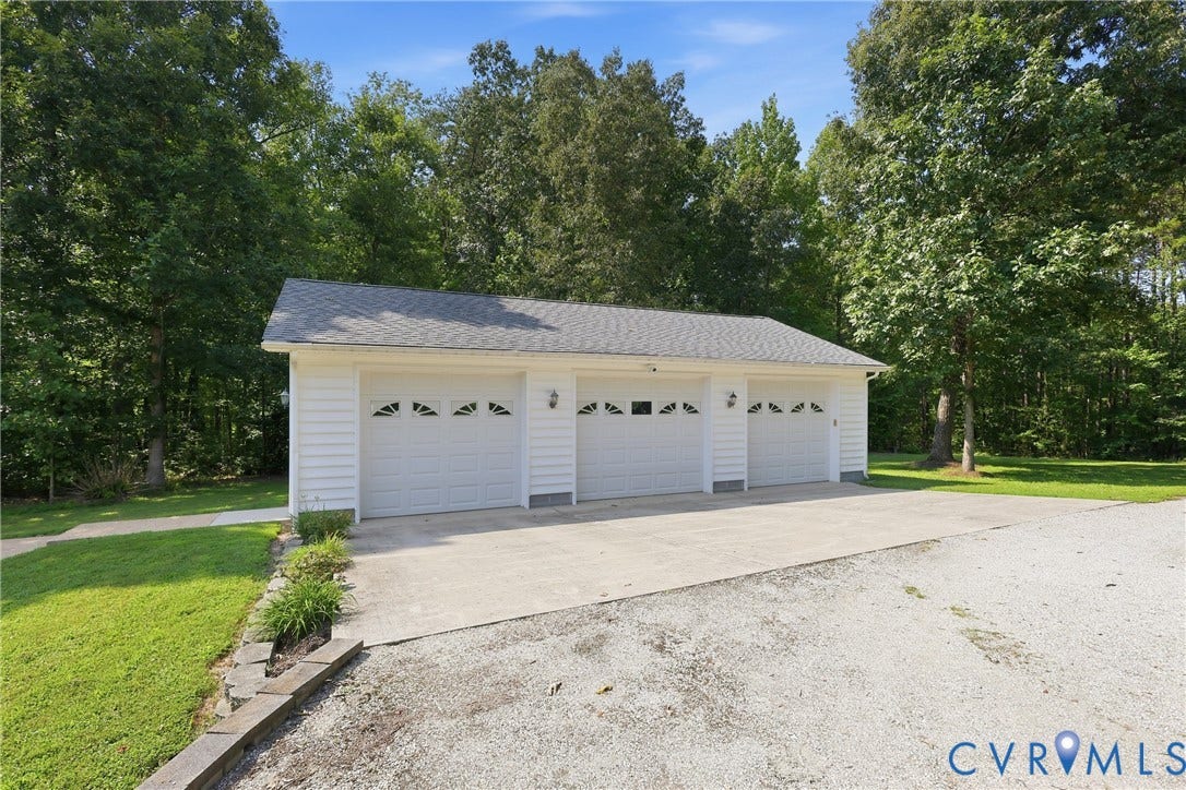 5295 Chimney Springs Drive, Saunders Acres, Goochland, VA 23063 White siding garage with three bays, featuring a shingle roof and concrete driveway