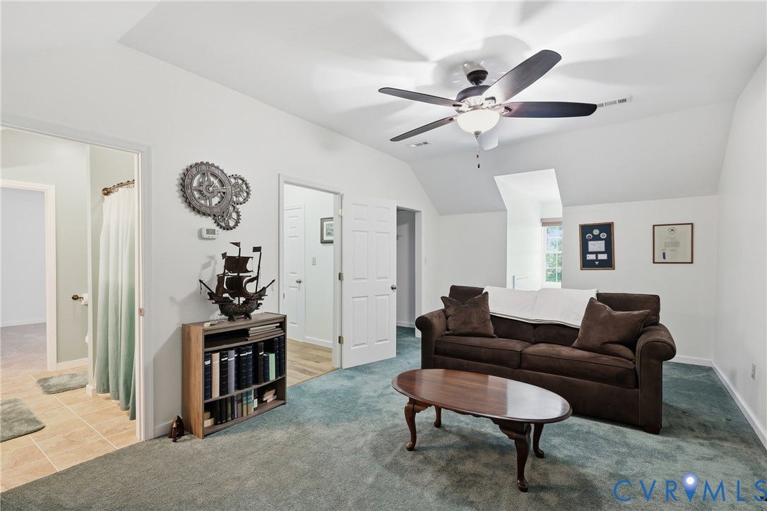 5295 Chimney Springs Drive, Saunders Acres, Goochland, VA 23063 Spacious living room with vaulted ceiling and ceiling fan, light wood-finish flooring, and neutral wall finishes
