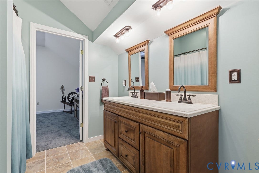 5295 Chimney Springs Drive, Saunders Acres, Goochland, VA 23063 Jack and Jill Bathroom- Dual vanity with wood-finish cabinetry and integrated sinks, complemented by individual framed mirrors and track lighting