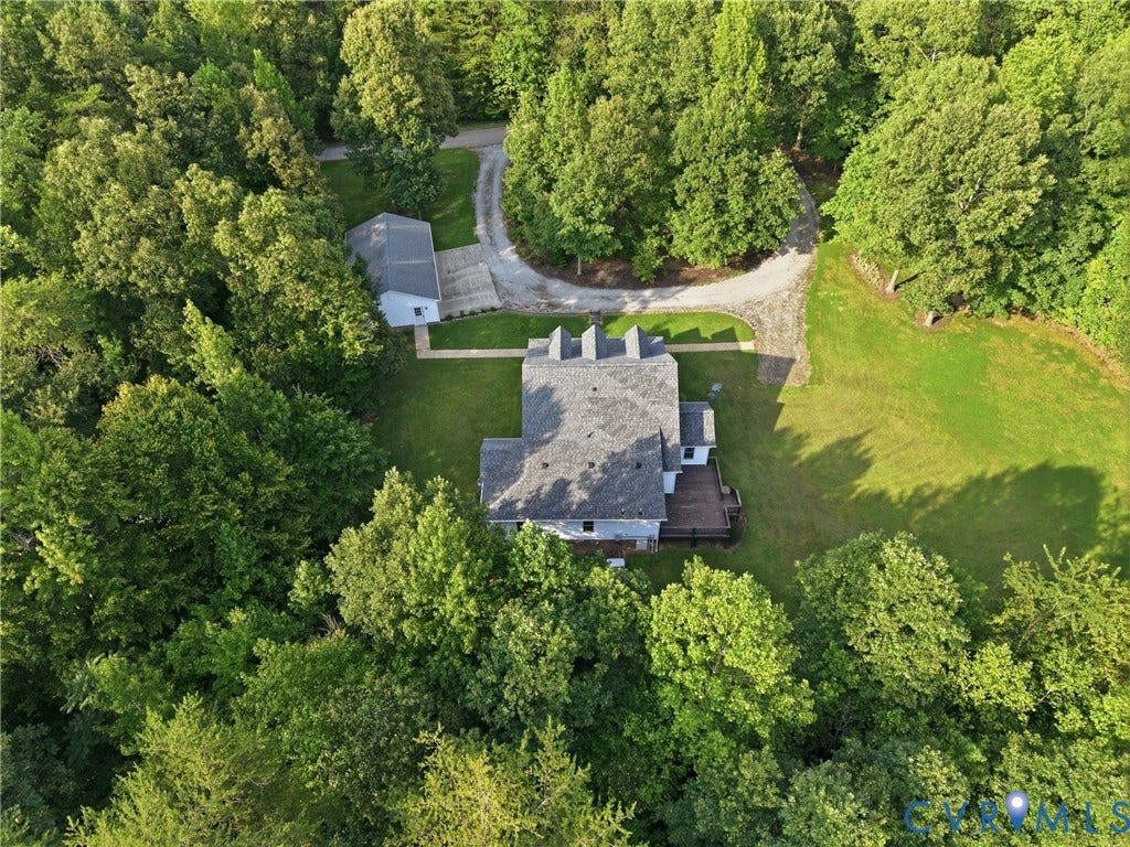 5295 Chimney Springs Drive, Saunders Acres, Goochland, VA 23063 Expansive property featuring a gravel driveway, lush green landscaping, a secondary detached structure, and a multi-level deck