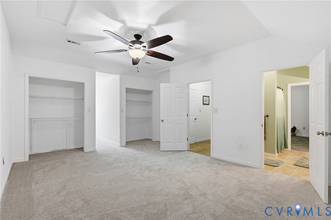 5295 Chimney Springs Drive, Saunders Acres, Goochland, VA 23063 Carpeted room featuring a ceiling fan with integrated lighting, two open closet spaces with shelving, and a tray ceiling