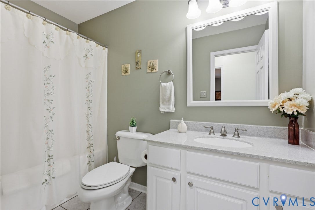 5295 Chimney Springs Drive, Saunders Acres, Goochland, VA 23063 Spa-inspired bathroom featuring a white vanity with ample storage, quartz countertop, polished nickel fixtures, and a large framed mirror with integrated lighting