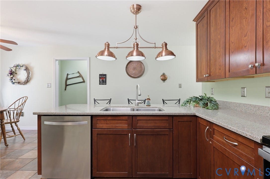 5295 Chimney Springs Drive, Saunders Acres, Goochland, VA 23063 Kitchen featuring wood cabinetry, stainless steel dishwasher, double basin sink, and pendant lighting