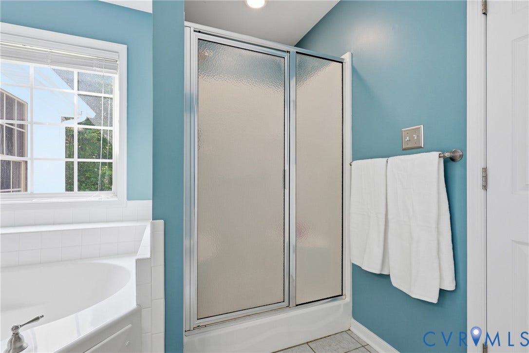 5295 Chimney Springs Drive, Saunders Acres, Goochland, VA 23063 Master bathroom featuring a frameless glass shower enclosure with chrome hardware, tile flooring, and soft blue accent walls