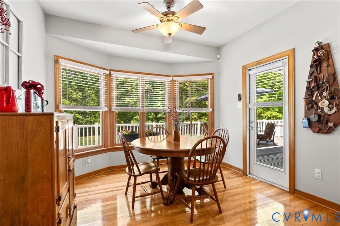3060 Moyer Road, Powhatan, VA 23139 Hardwood flooring with a bay window, ceiling fan with integrated lighting, and a white door with a glass panel