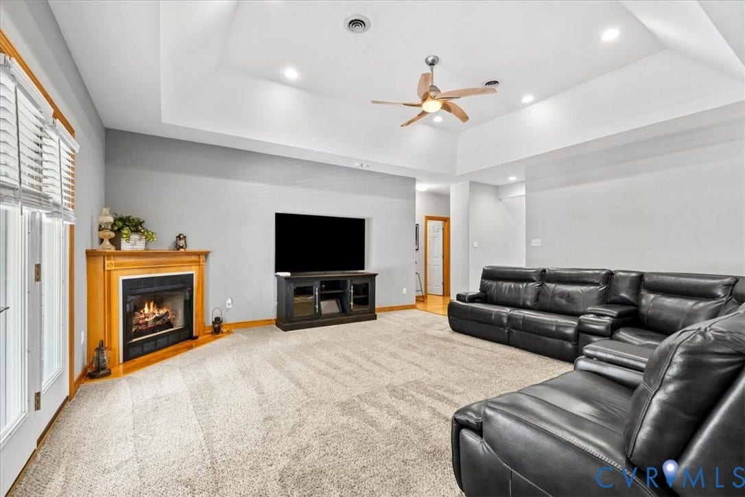 3060 Moyer Road, Powhatan, VA 23139 Recessed lighting, wood-finish flooring, corner fireplace with wood mantel, ceiling fan, and tray ceiling