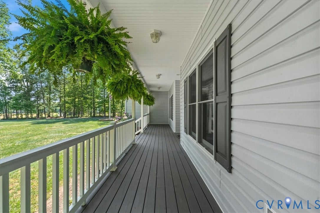 3060 Moyer Road, Powhatan, VA 23139 Expansive covered porch featuring durable decking, white railing, and exterior siding with decorative shutters