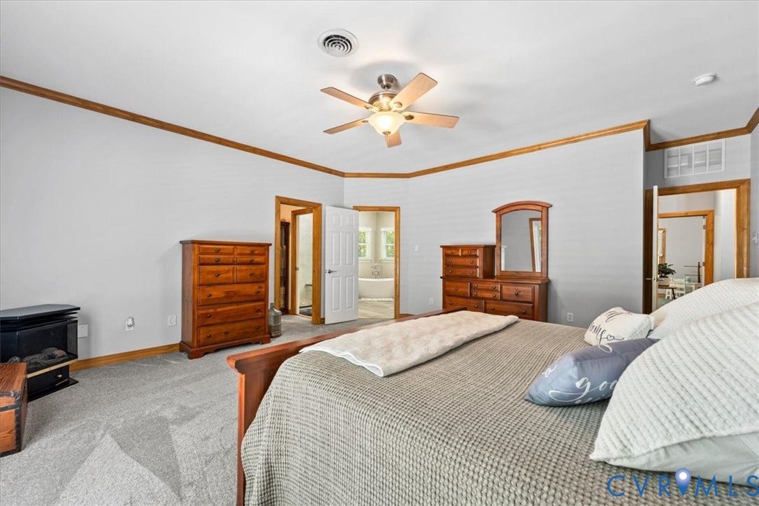 3060 Moyer Road, Powhatan, VA 23139 Spacious primary bedroom featuring hardwood furnishings, ceiling fan with integrated lighting, carpet flooring, and an ensuite bathroom