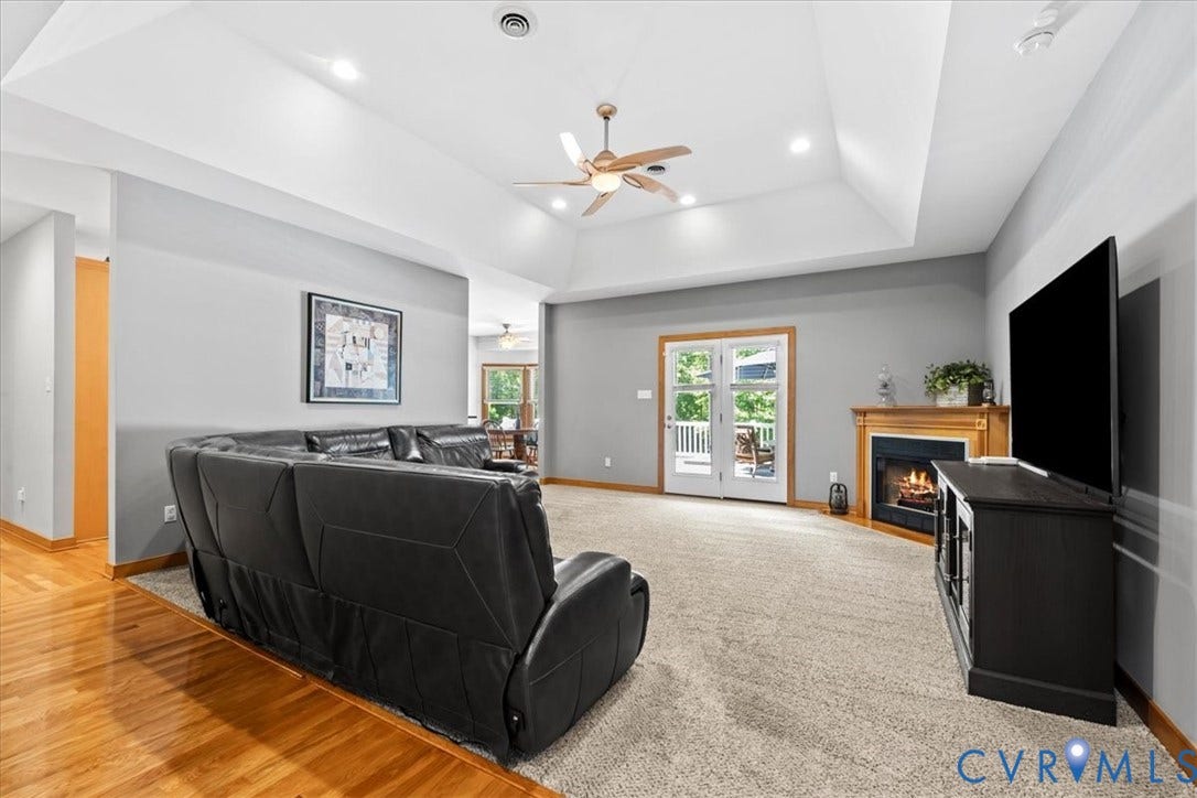 3060 Moyer Road, Powhatan, VA 23139 Spacious open-concept living area featuring hardwood flooring, coffered ceiling with ceiling fan, and abundant natural light from French doors