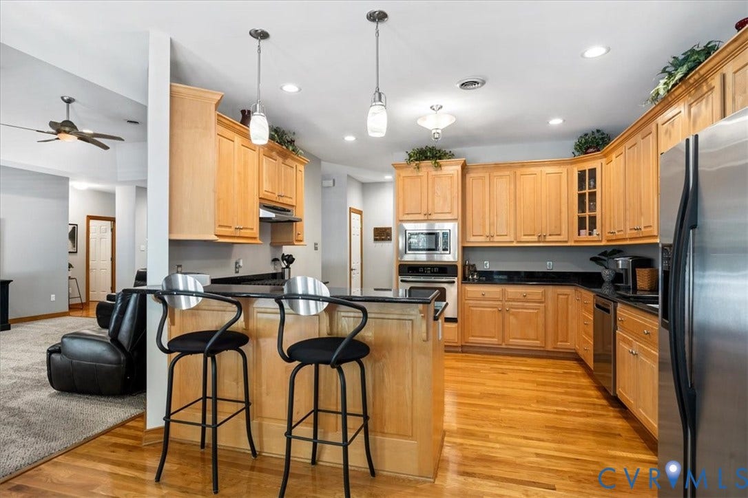 3060 Moyer Road, Powhatan, VA 23139 Kitchen featuring wood cabinetry, dark countertops, a built-in oven, and a kitchen island with pendant lighting
