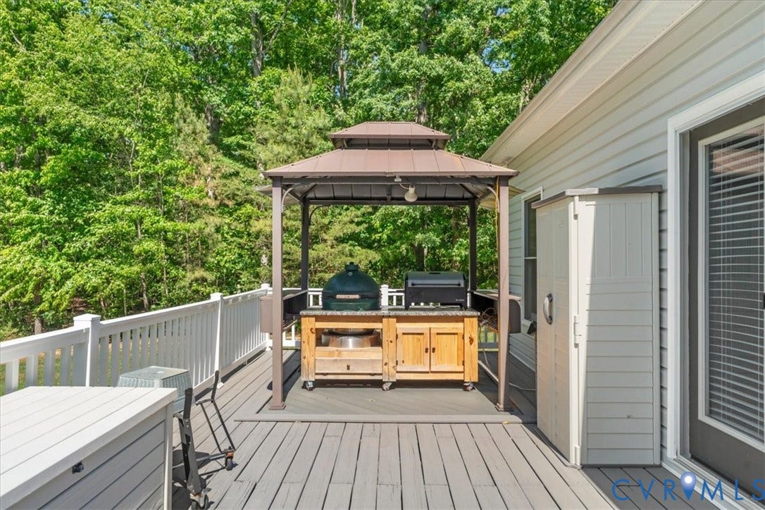 3060 Moyer Road, Powhatan, VA 23139 Expansive composite deck featuring composite decking with white railings, a built-in seating area, and a freestanding gazebo with integrated outdoor kitchen cabinetry and grill