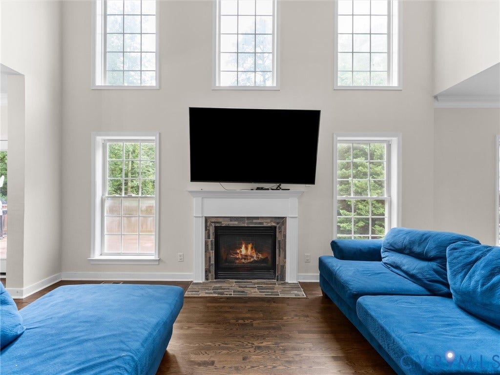 5017 Sadler Glen Place, Glen Allen, VA 23060 Two-story living area featuring a fireplace with stone surround, a white mantel, and wood-finish flooring