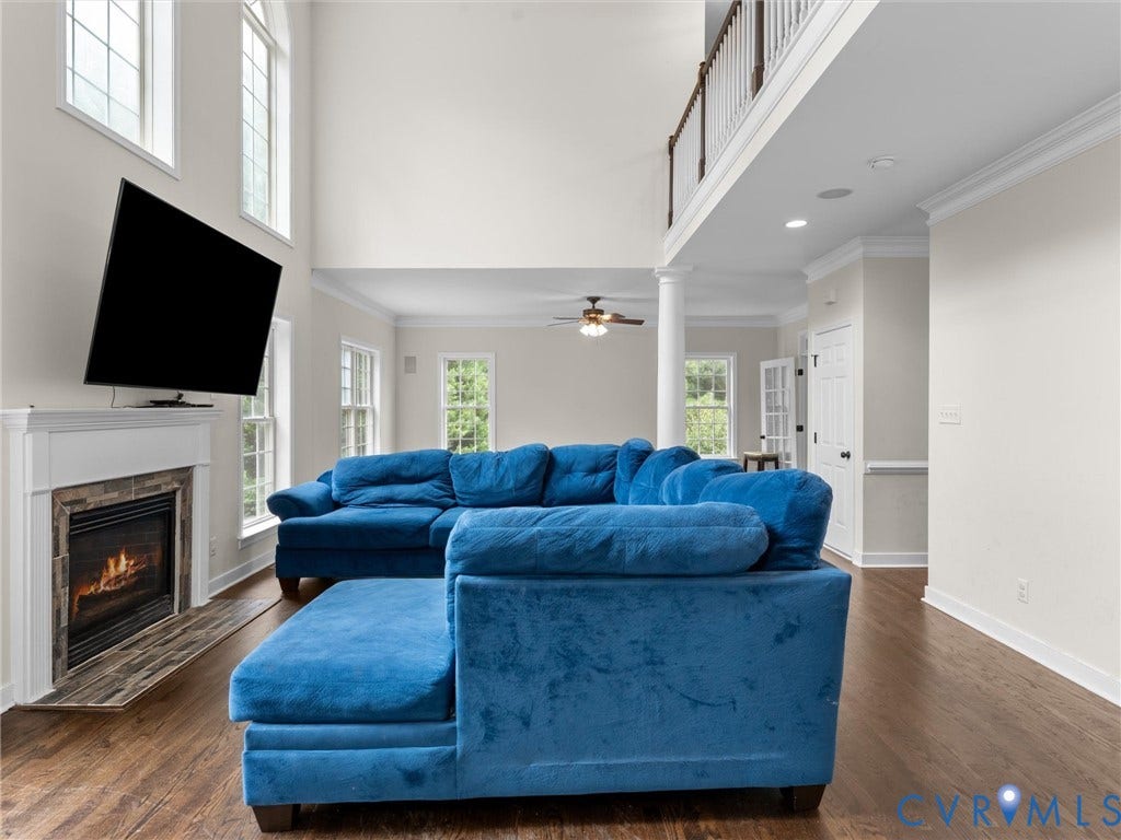 5017 Sadler Glen Place, Glen Allen, VA 23060 Two-story ceiling, wood-finish flooring, fireplace with a tile surround, white mantel, and a second-story interior balcony with dark wood railings