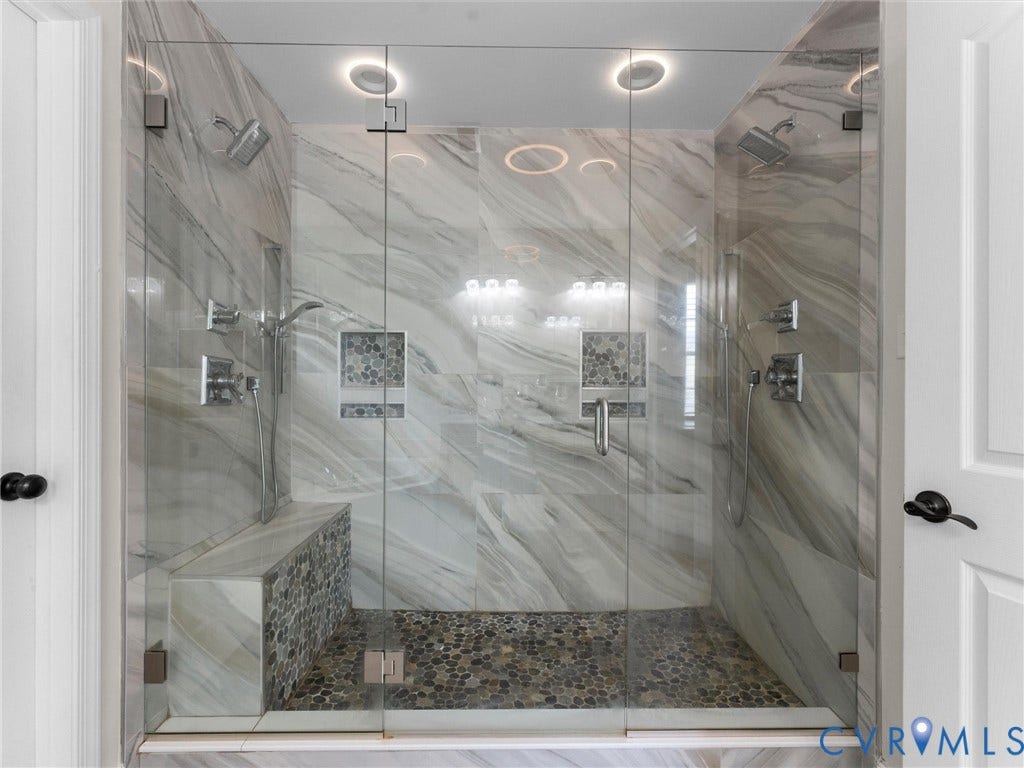 5017 Sadler Glen Place, Glen Allen, VA 23060 Walk-in shower with dual shower heads, glass enclosure, stone-finish tile, pebble flooring, and integrated bench seating