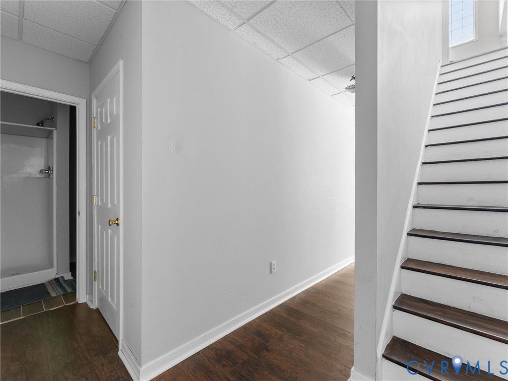 5017 Sadler Glen Place, Glen Allen, VA 23060 Wood-finish flooring with white trim, paneled door with brass hardware, and a staircase with wood-finish treads