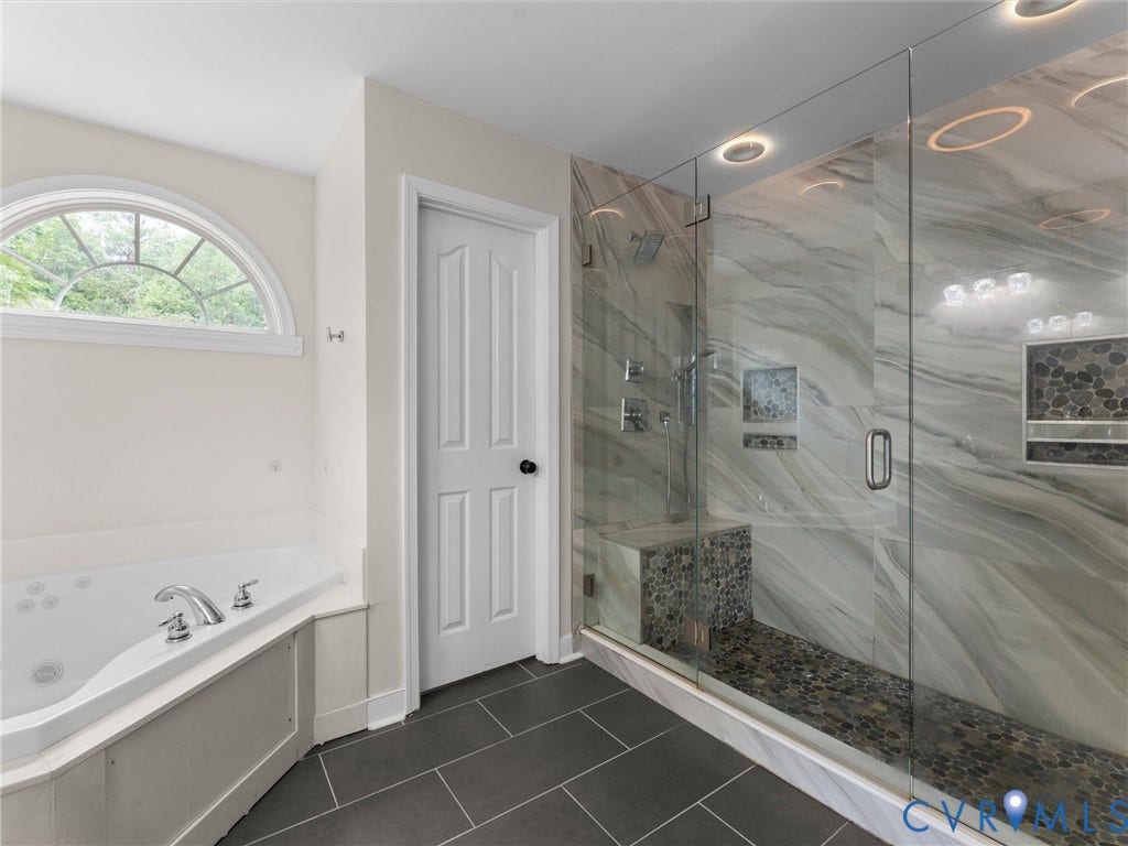 5017 Sadler Glen Place, Glen Allen, VA 23060 Corner soaking tub with polished chrome fixtures and an arched transom window