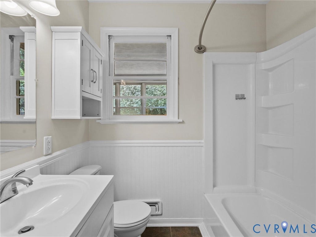 White vanity with an integrated sink and brushed nickel faucet