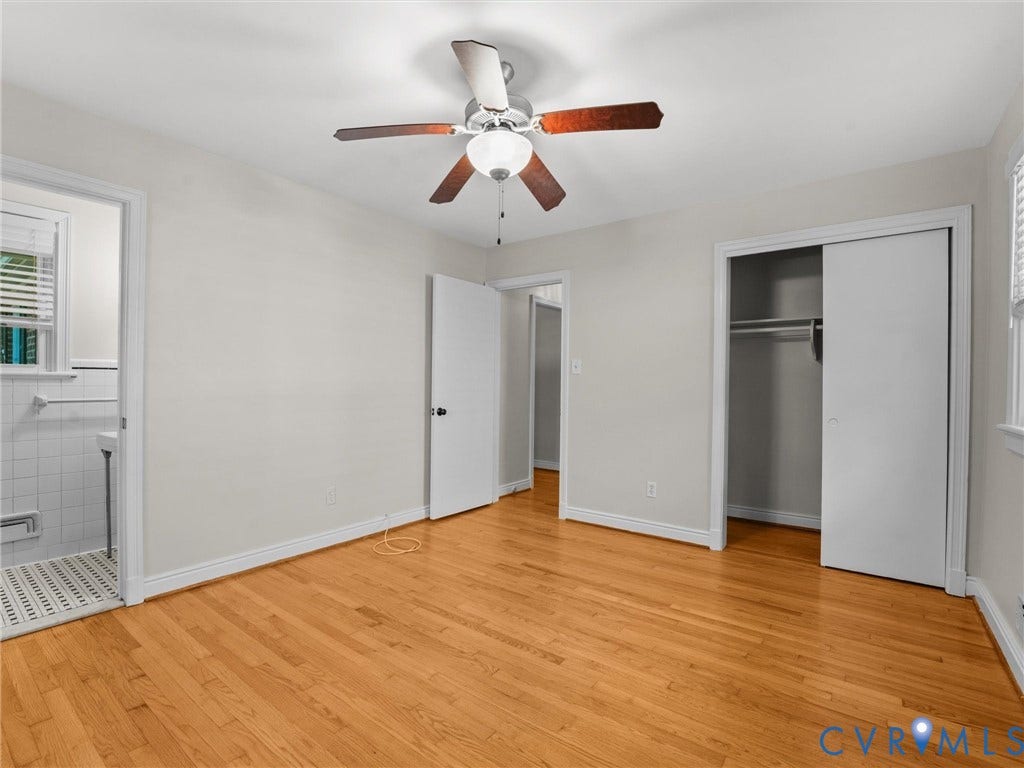 Hardwood flooring, ceiling fan with integrated lighting, sliding closet doors, white wall paint, and white trim