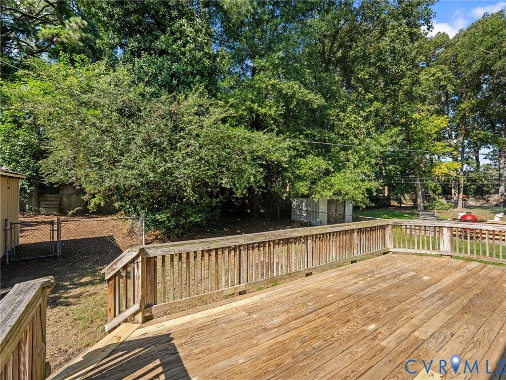 Expansive wooden deck with wooden railings, offering an elevated outdoor space