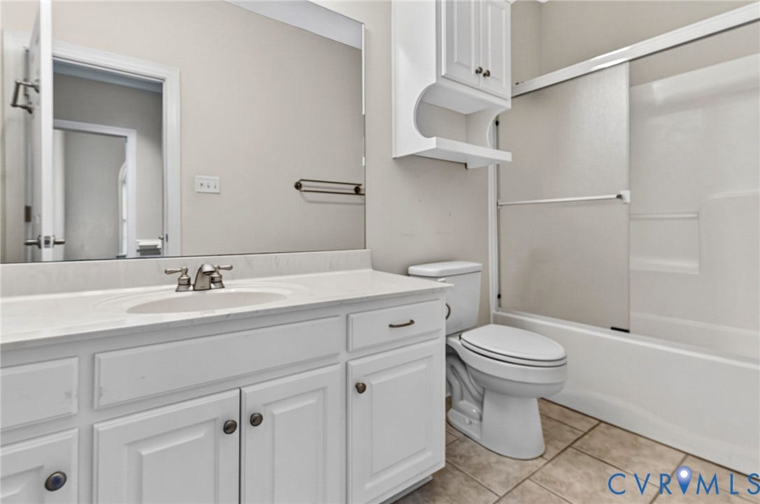 White vanity with integrated sink, brushed nickel faucet, and white upper cabinetry