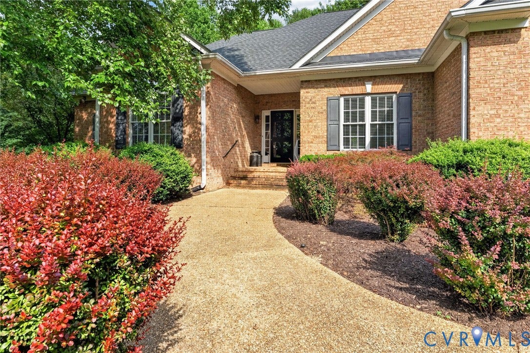 Brick exterior with a gabled roofline, complemented by a concrete aggregate pathway