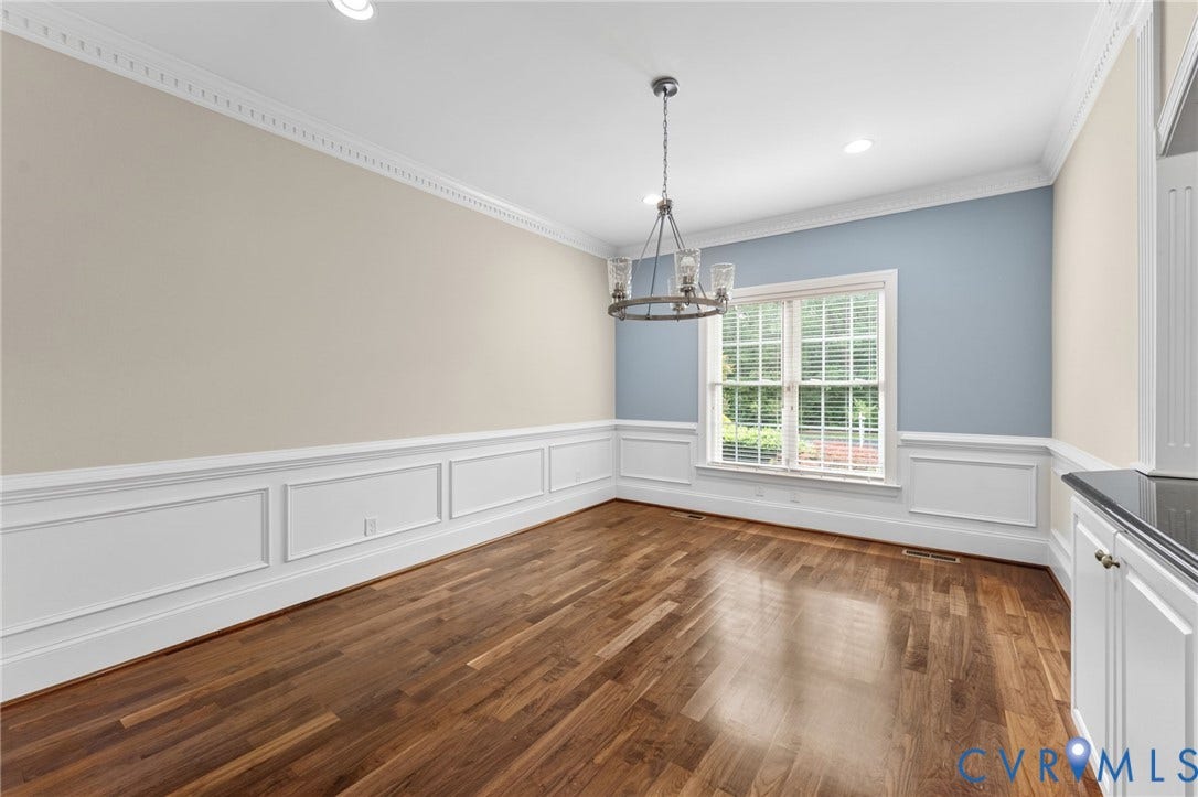 Hardwood flooring, crown molding, wainscoting, recessed lighting, and a multi-pane window
