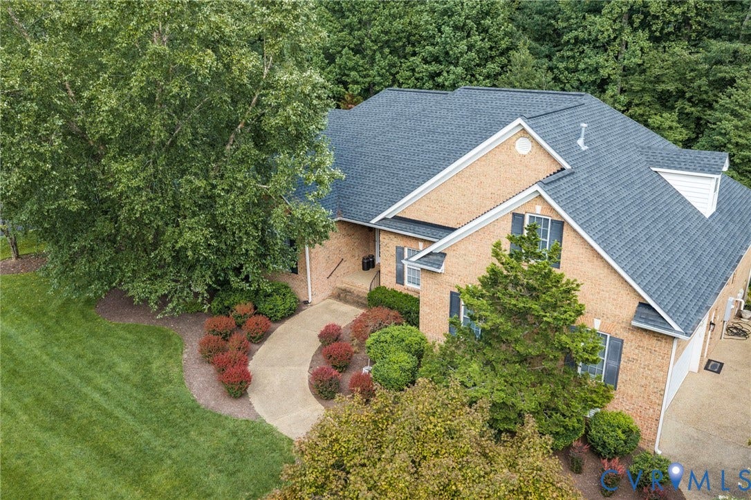 Brick exterior with dark shingle roofing