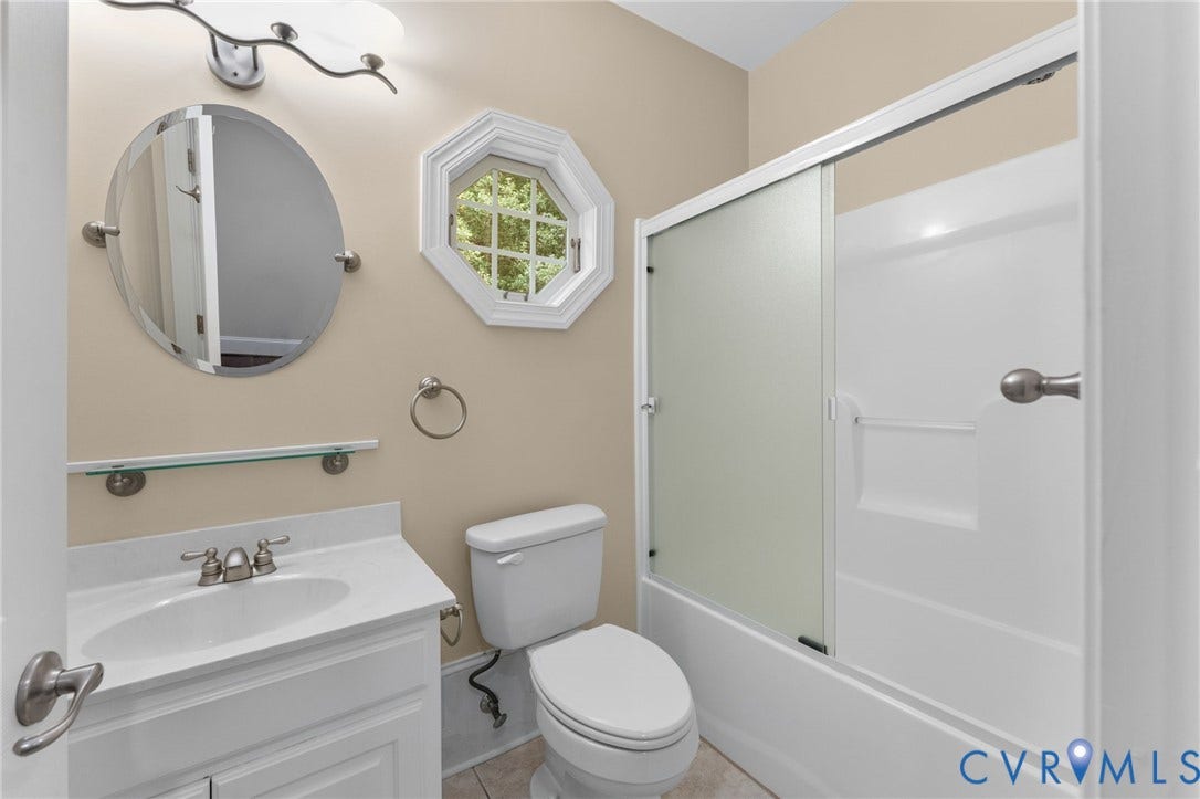 Fresh and bright bathroom with a white vanity sink, chrome fixtures, and tile surround