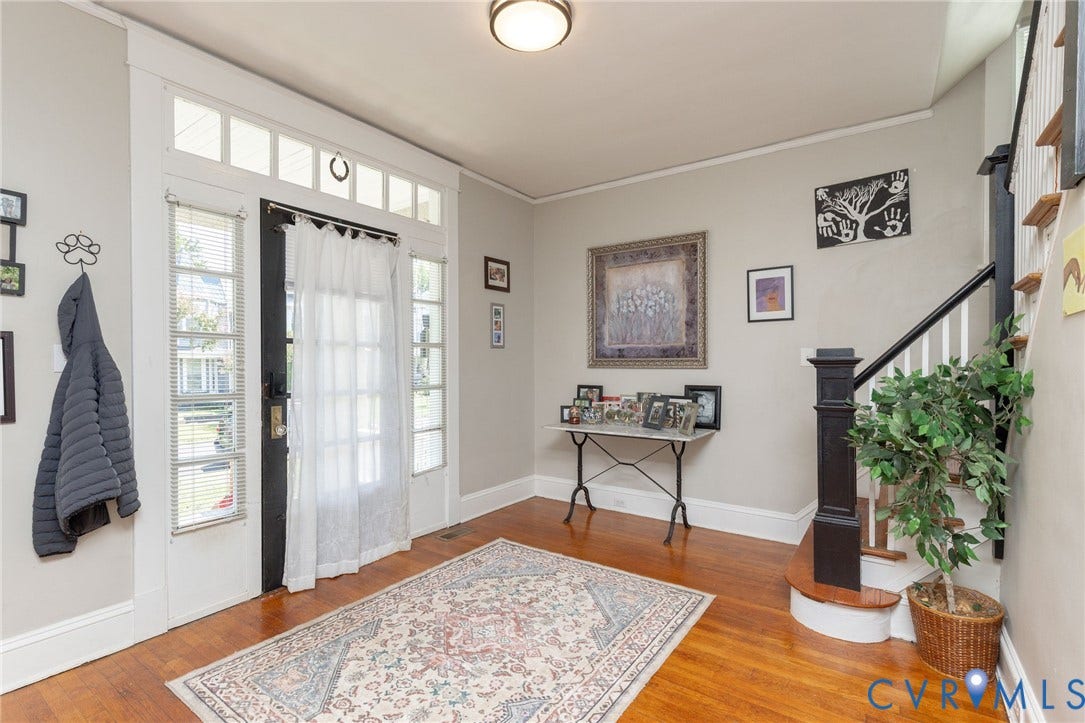 2726 Hanes Avenue, Brookland Park, Richmond, VA 23222 Hardwood flooring, white trim, traditional light fixture, painted walls, and a staircase with a dark wood newel post