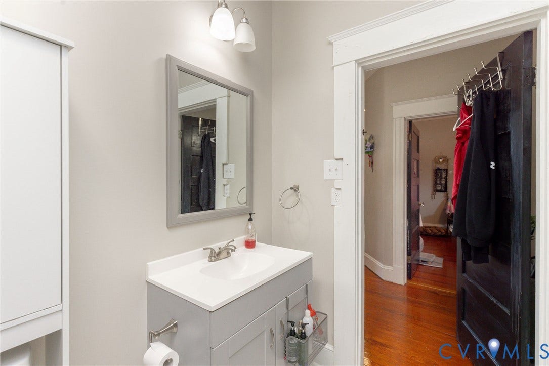 2726 Hanes Avenue, Brookland Park, Richmond, VA 23222 White vanity with integrated sink, rectangular framed mirror, and chrome-finish fixtures