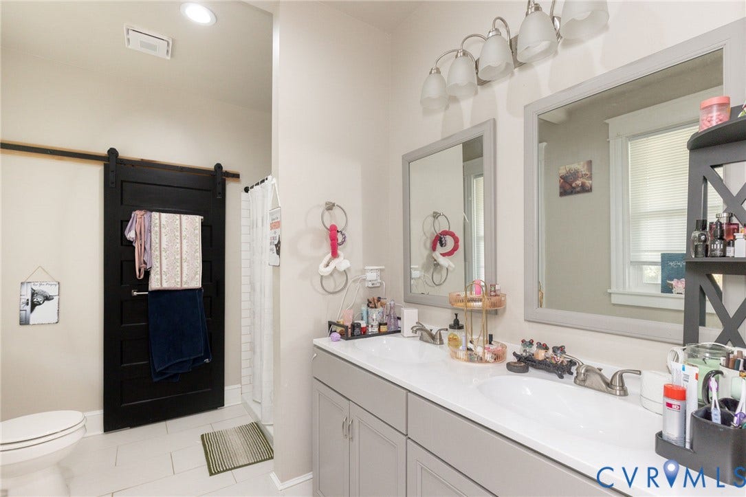 2726 Hanes Avenue, Brookland Park, Richmond, VA 23222 Dual vanity with gray cabinetry and integrated sinks, framed mirrors, and a multi-light fixture