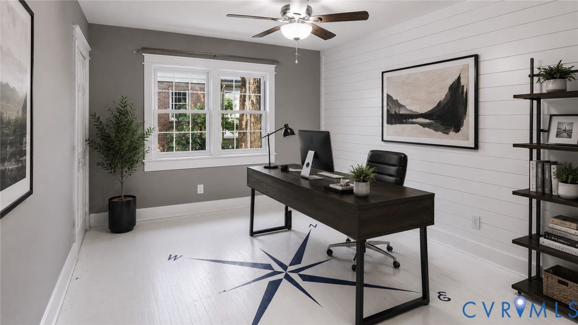 Hardwood flooring with compass detail, dual windows with white trim, shiplap accent wall, and a ceiling fan with integrated lighting