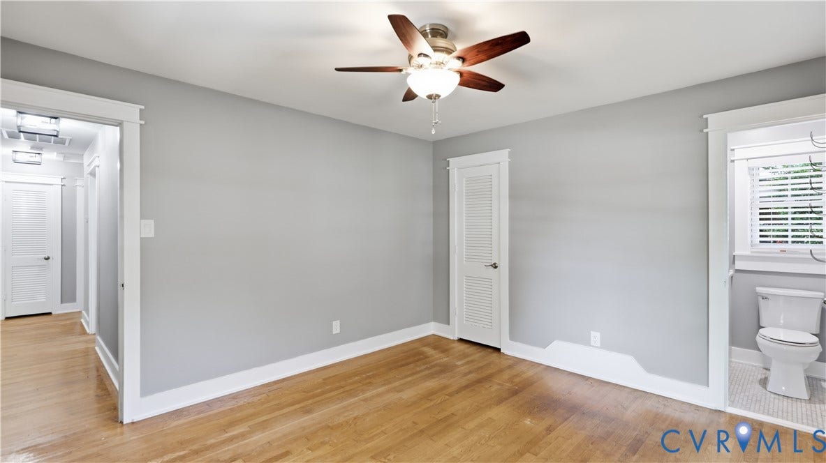 Hardwood flooring, ceiling fan with integrated lighting, louvered closet door, white trim, and white wall finishes