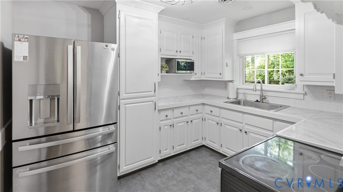 White cabinetry with crown molding, stainless steel appliances, light-toned countertops, white subway tile backsplash, and a stainless steel sink with a gooseneck faucet