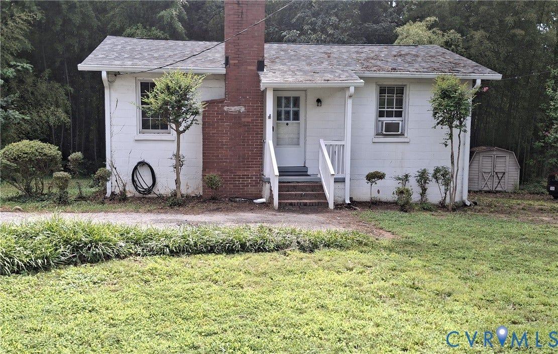 7107 Old Westham Road, Stratford Hills, Richmond, VA 23225 Charming cottage-style home featuring a brick chimney, white exterior with horizontal siding, and a front-facing entrance with steps and railings