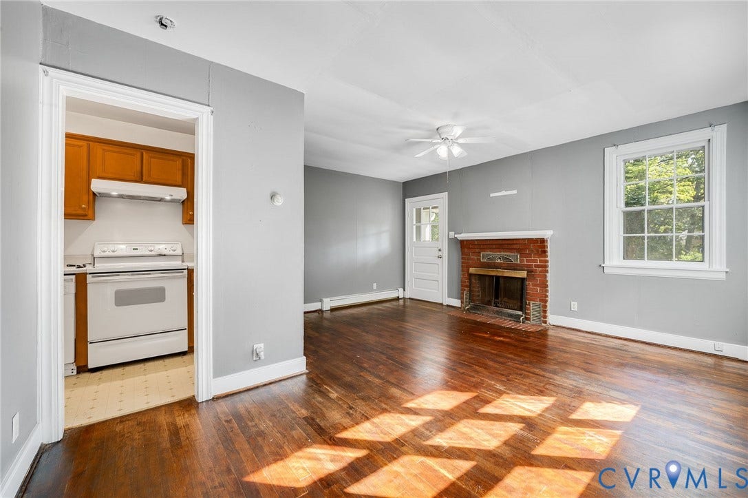 7107 Old Westham Road, Stratford Hills, Richmond, VA 23225 Wood-finish flooring, brick fireplace with a brass firebox, ceiling fan, and white trim throughout