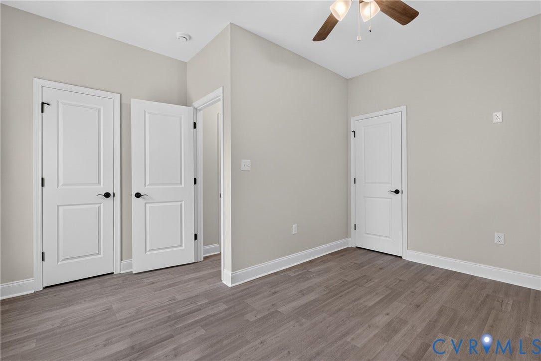 6541 Hardee Haven Place, Midlothian, VA 23112 Light gray wall paint, wood-finish flooring, white paneled doors with black hardware, and a ceiling fan with integrated lighting